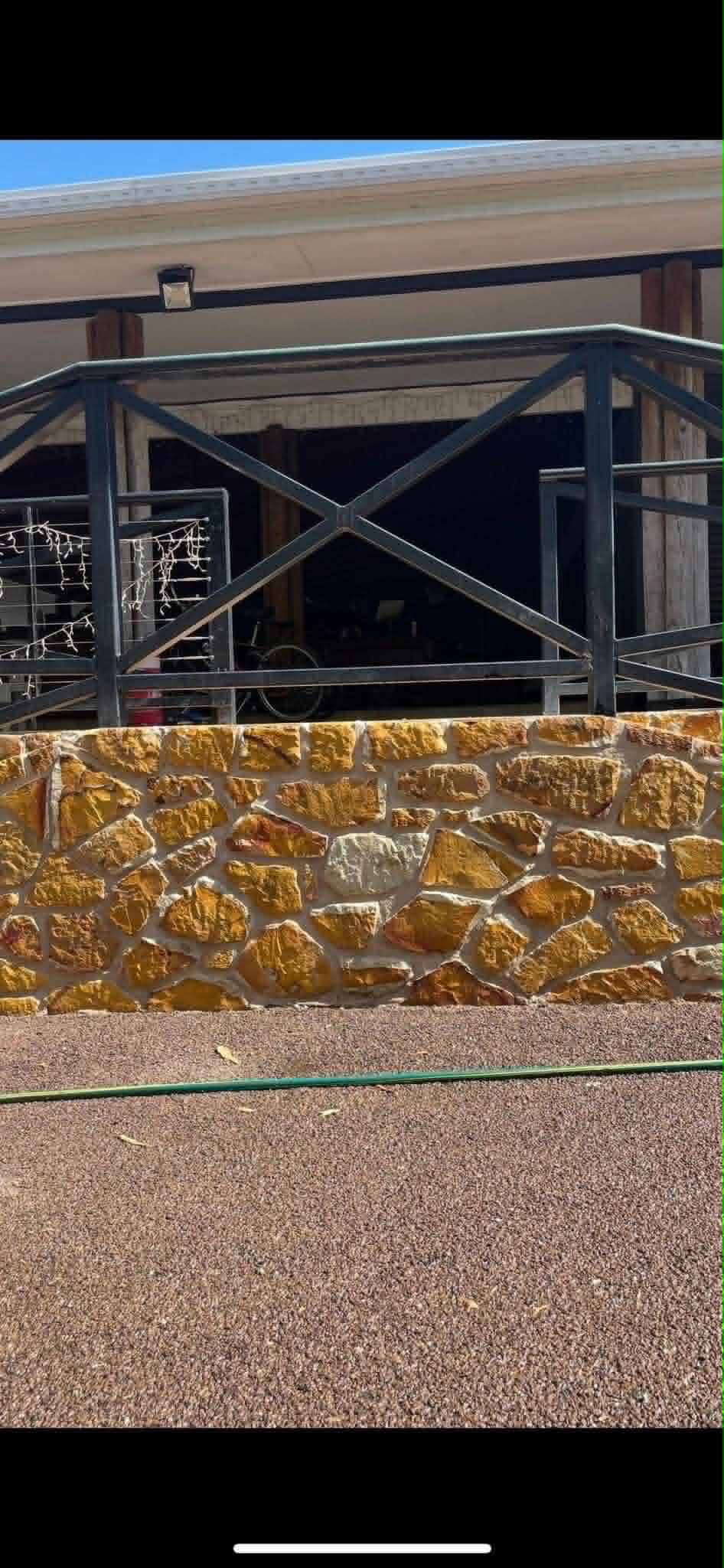 Random-coursed sandstone feature wall under a balcony