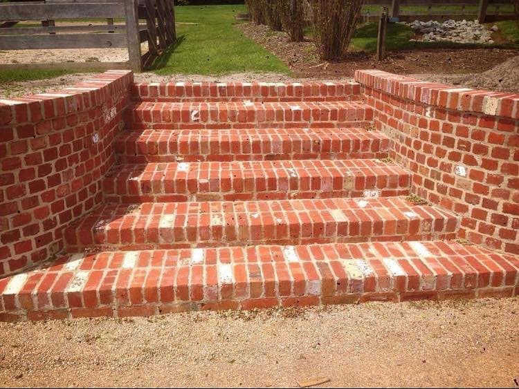 Curved red-brick staircase returning into a landing