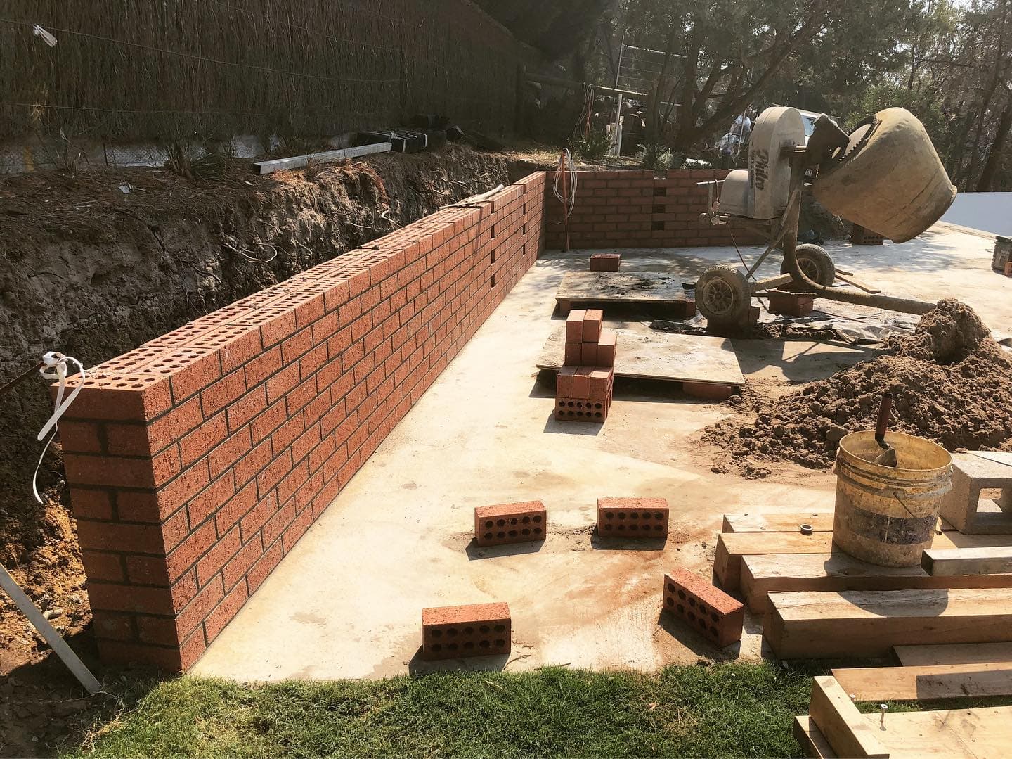Red-brick retaining wall with drainage set behind, on a rural Berry Springs block.
