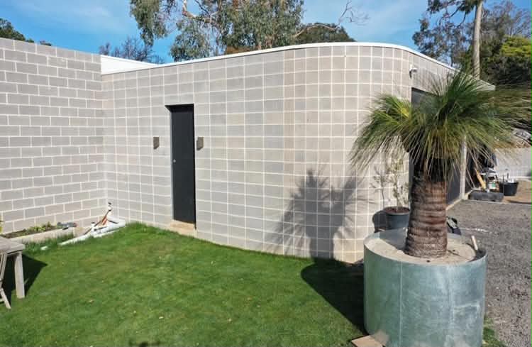 Finished grey block building with a smooth radius corner and clean render-ready face, Top End.